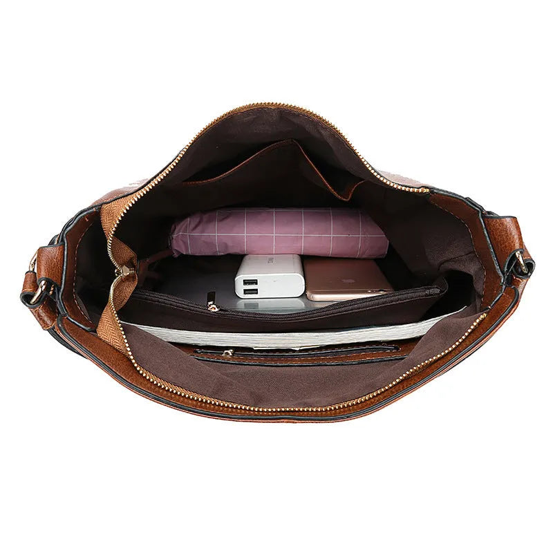 Hobos zipper bucket bag in black with adjustable shoulder strap on a woman's shoulder