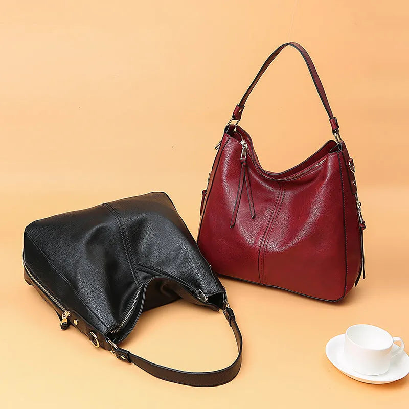 Hobos zipper bucket bag in black with adjustable shoulder strap on a woman's shoulder