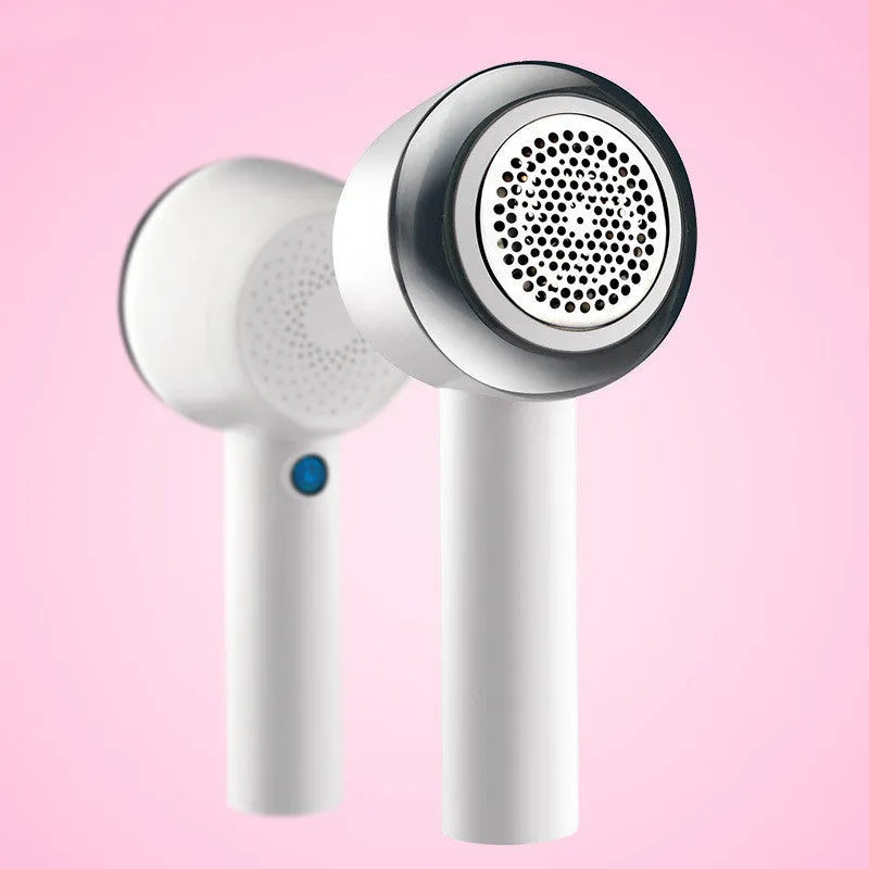 White rechargeable clothes shaver and fabric pill remover on a wooden surface.