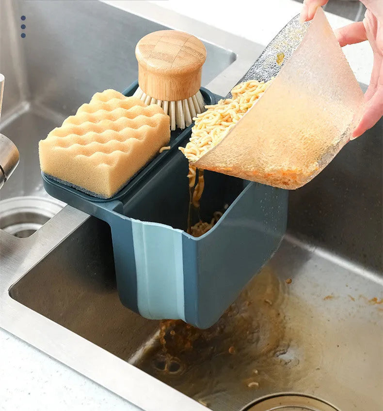 Foldable grey kitchen sink drain basket with suction cup hanging on sink edge