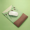 Green kiwi fruit themed mouse pad with integrated thick grey wrist support cushion on a desk.