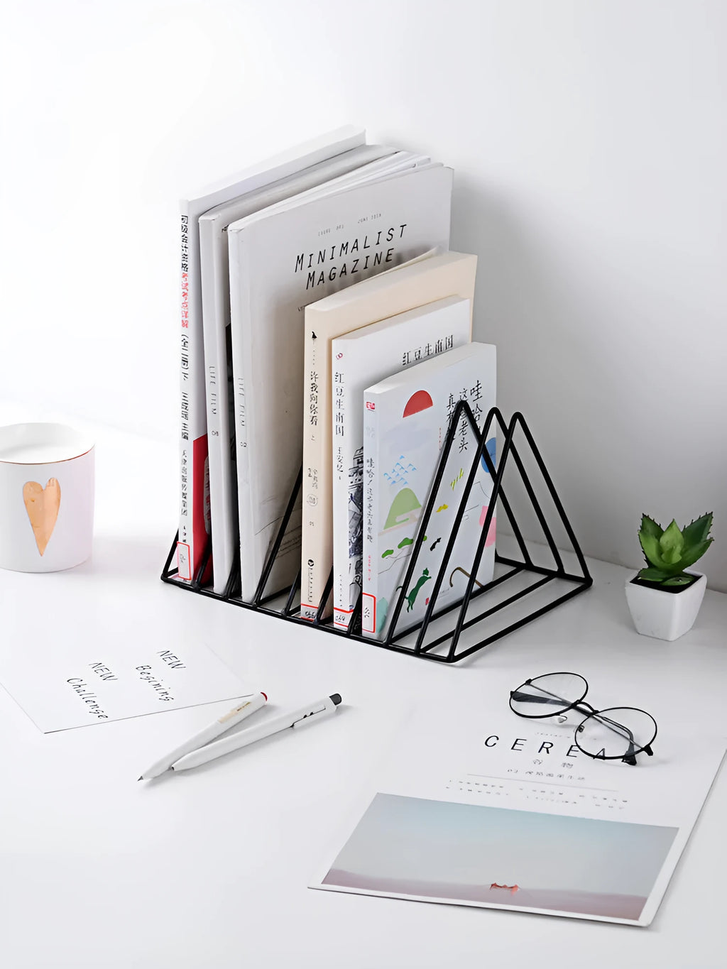 Wrought iron triangle book stand in black on a desk holding a book upright