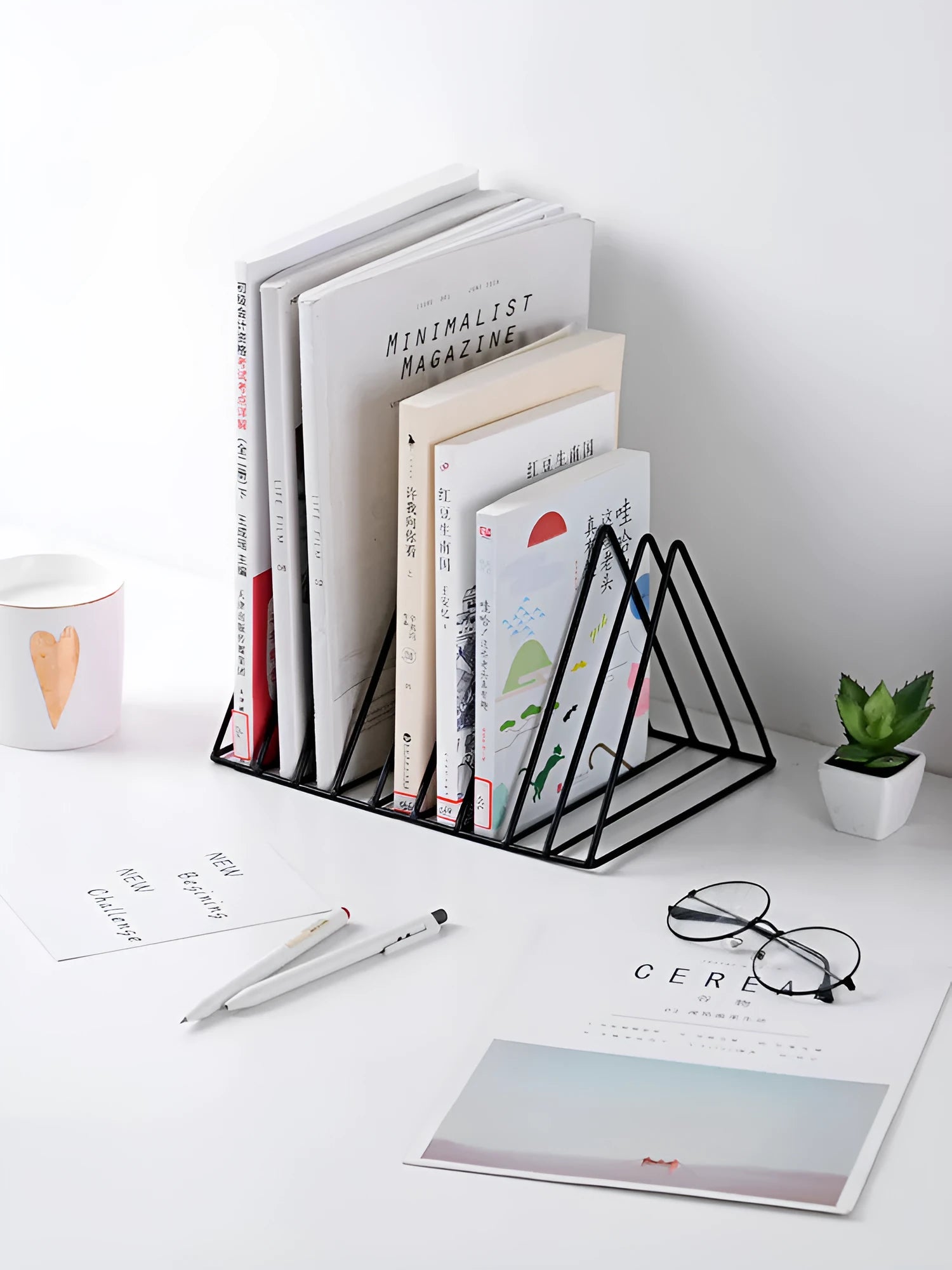Wrought iron triangle book stand in black on a desk holding a book upright