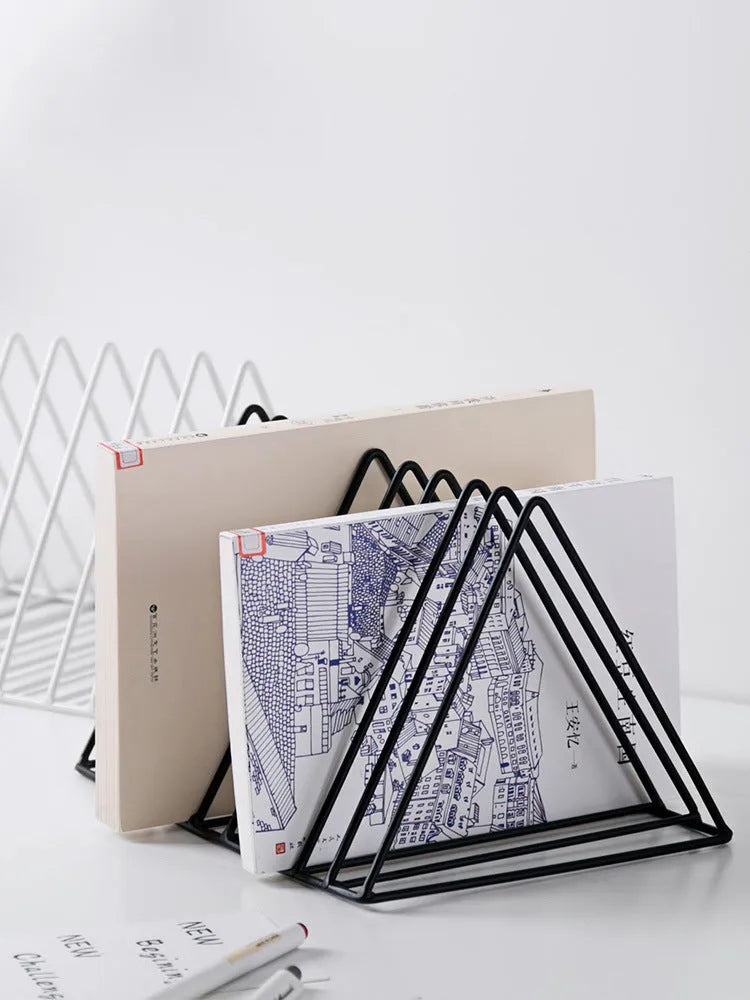 Wrought iron triangle book stand in black on a desk holding a book upright