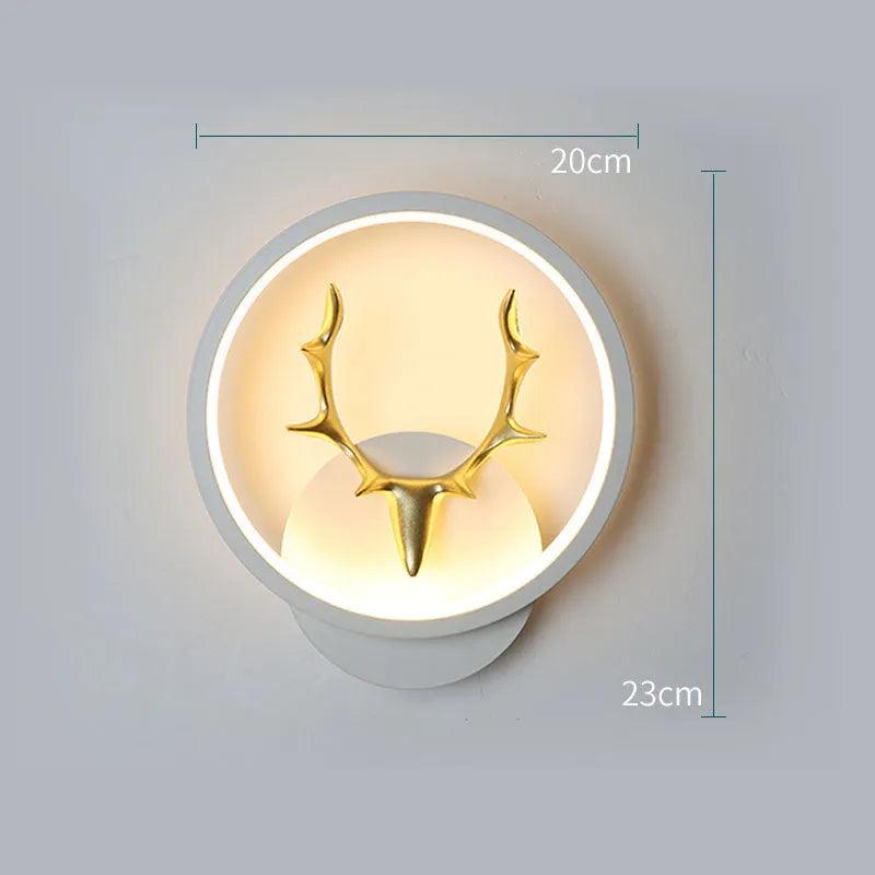 Deer antler shaped wall lamp with remote control on a light-coloured wall.