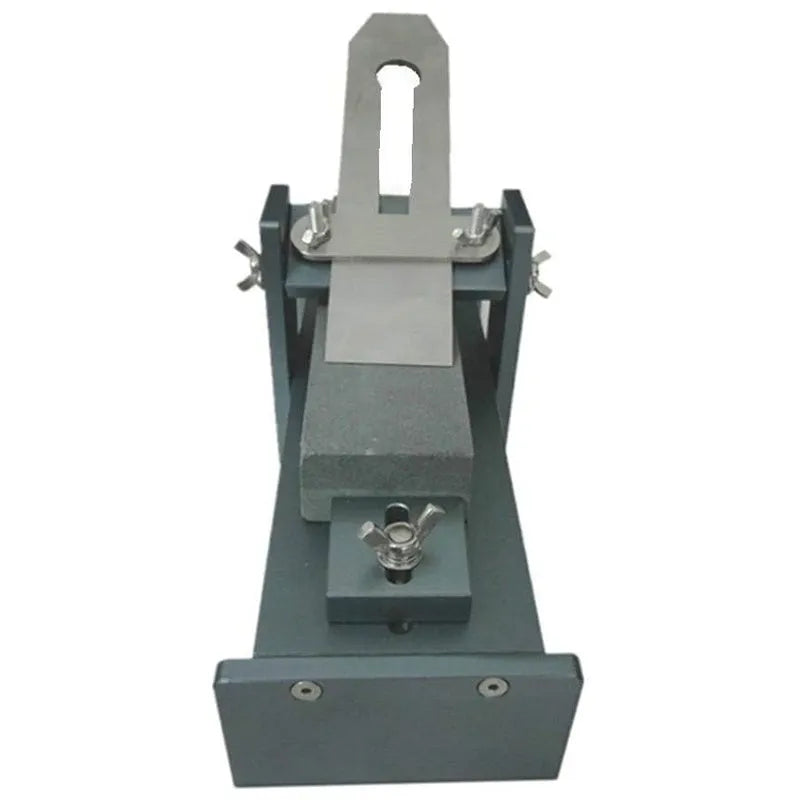 Aluminium alloy fixed angle sharpening tool for woodworking planers, chisels and carving knives on a workbench.