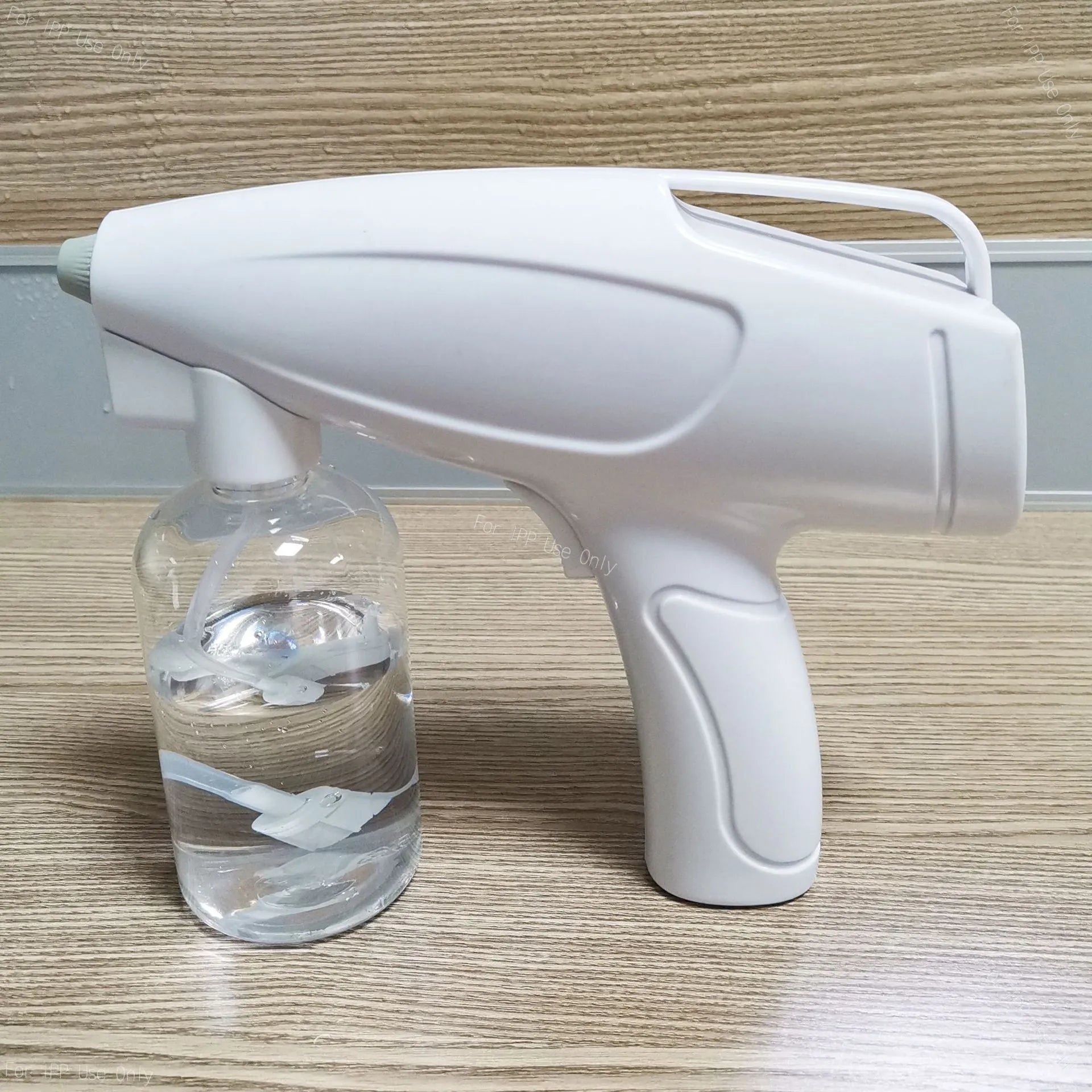 White cordless electric spray disinfection gun with USB-C charging port and bottle.