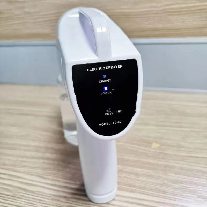 White cordless electric spray disinfection gun with USB-C charging port and bottle.