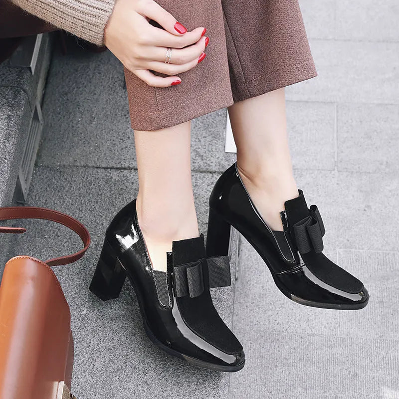 Women's patent leather high heel shoes with thick heels in black colour showing square toe design