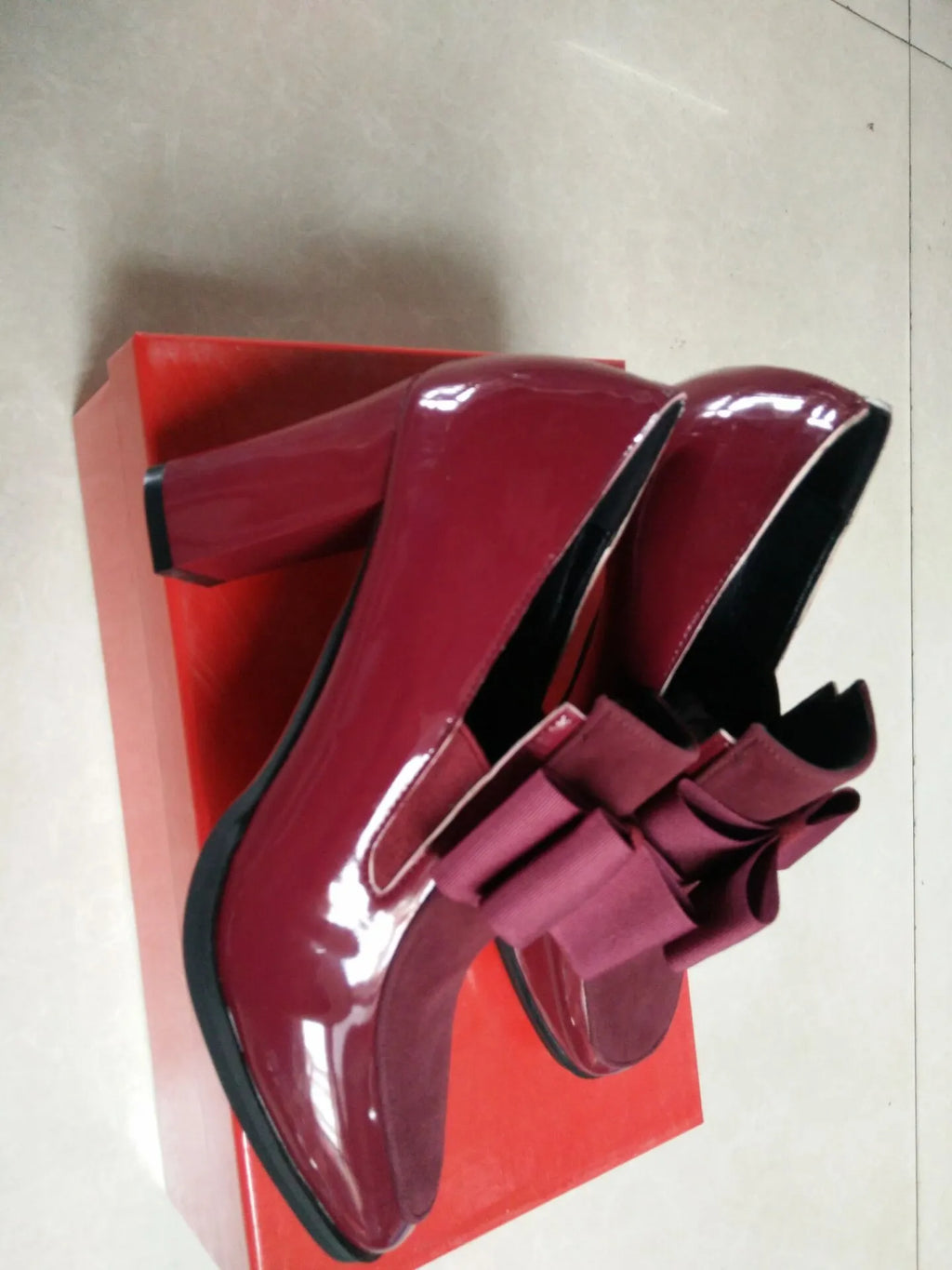 Women's patent leather high heel shoes with thick heels in black colour showing square toe design