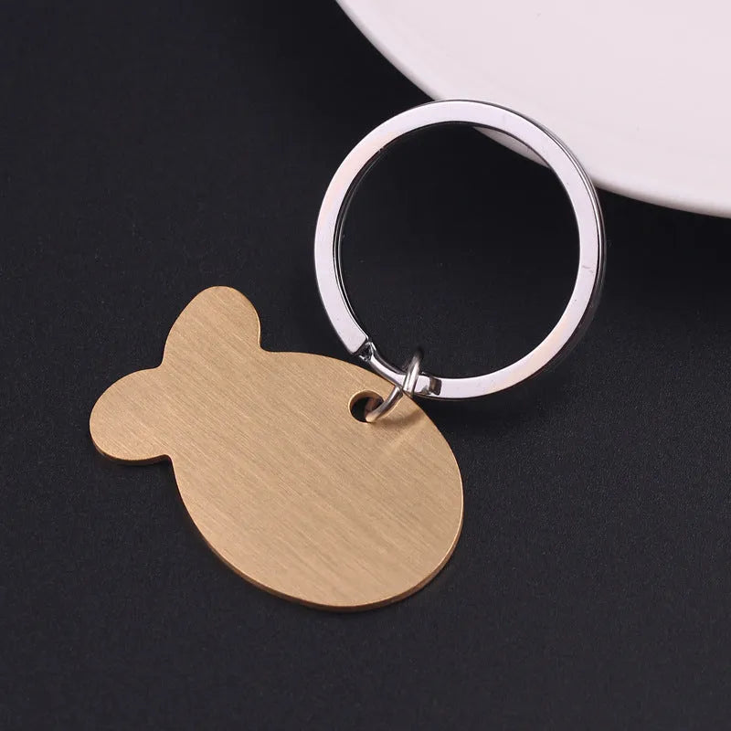 Personalised stainless steel bone-shaped pet ID tag keychain engraved with a name, available in gold, silver, or rose gold