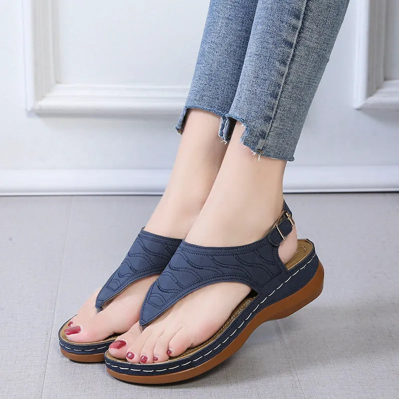 Women's wedge heel sandal in a solid colour with an adjustable back strap buckle.