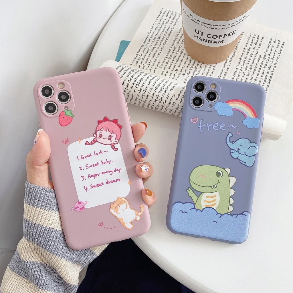 Blue soft shell iPhone case with printed cartoon dinosaur design, shown next to a pink version with a cat girl print.