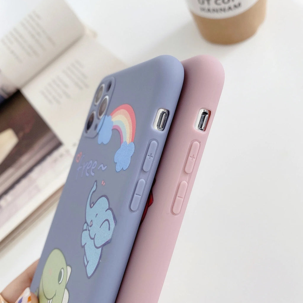 Blue soft shell iPhone case with printed cartoon dinosaur design, shown next to a pink version with a cat girl print.