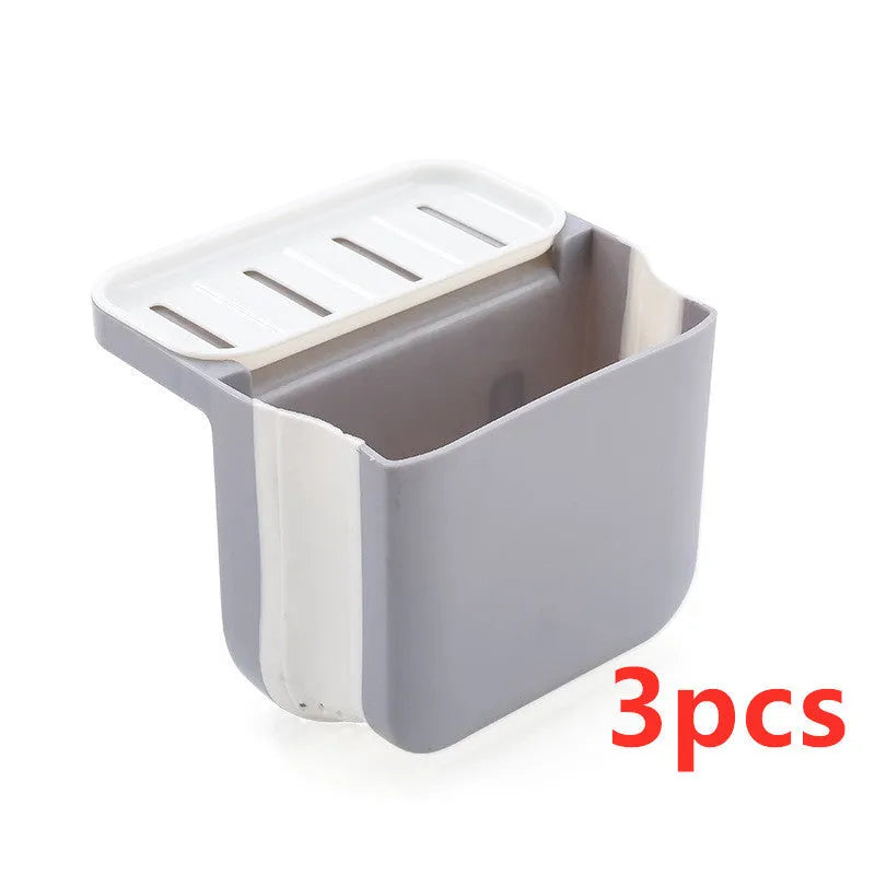 Foldable grey kitchen sink drain basket with suction cup hanging on sink edge