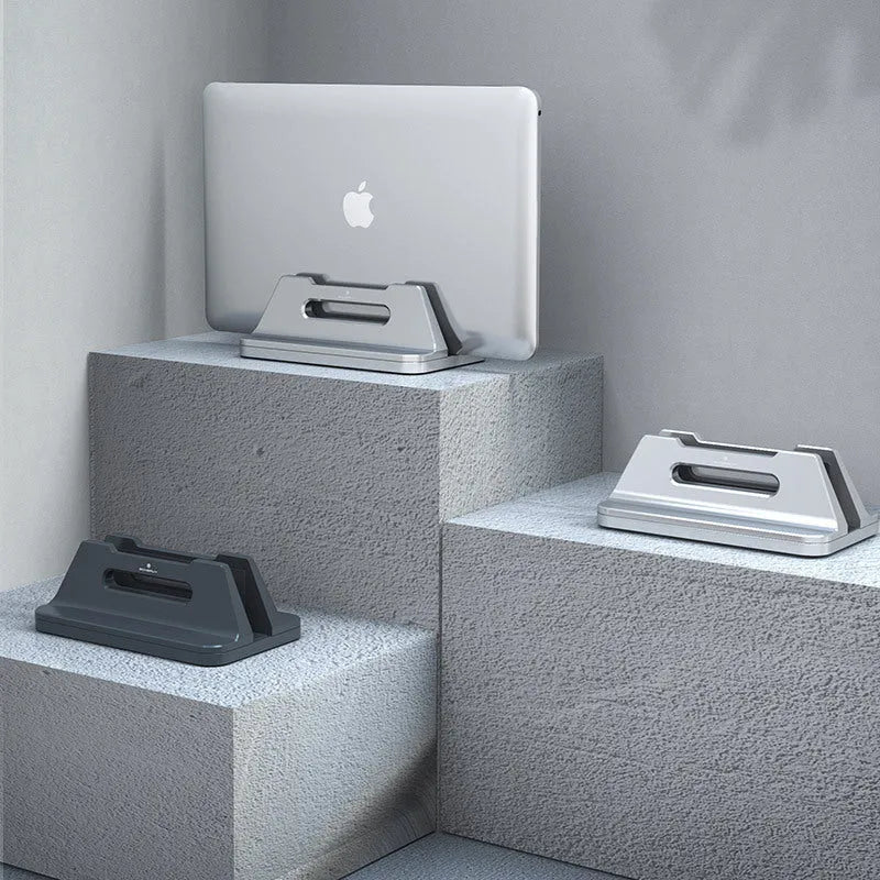 Silver aluminium alloy vertical laptop storage bracket on desk holding a notebook computer