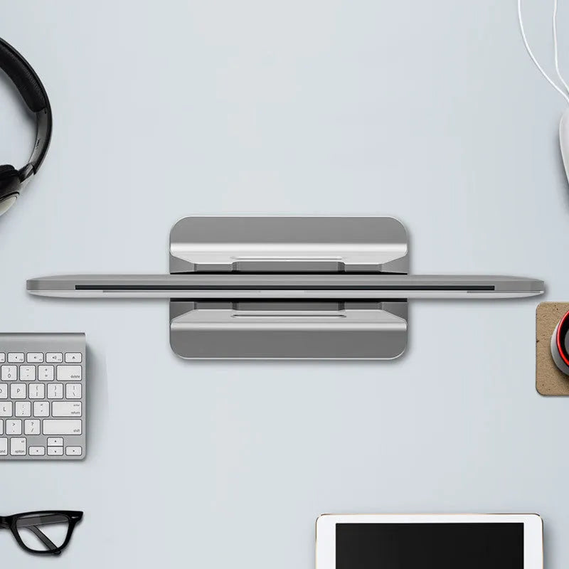 Silver aluminium alloy vertical laptop storage bracket on desk holding a notebook computer