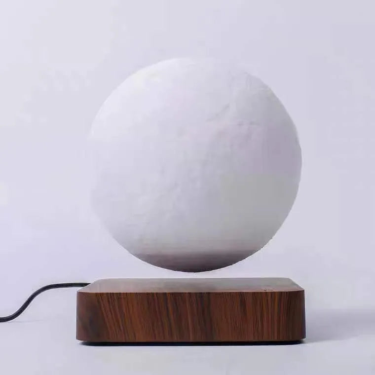 Magnetic levitation moon night light with 14cm 3D-printed planet suspended above a dark peach wood base