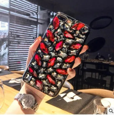 Clear rhinestone crystal gem iPhone case on a mobile phone, showing decorative back detail.