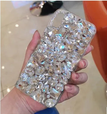 Clear rhinestone crystal gem iPhone case on a mobile phone, showing decorative back detail.