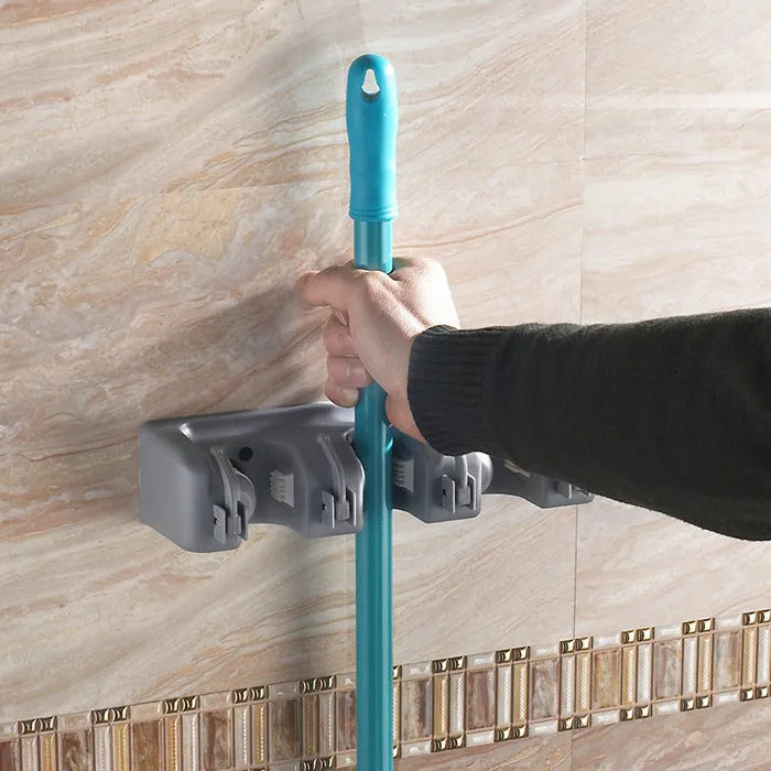 Plastic mop hook wall hanger with 4 hooks for drilling installation, holding a mop and broom
