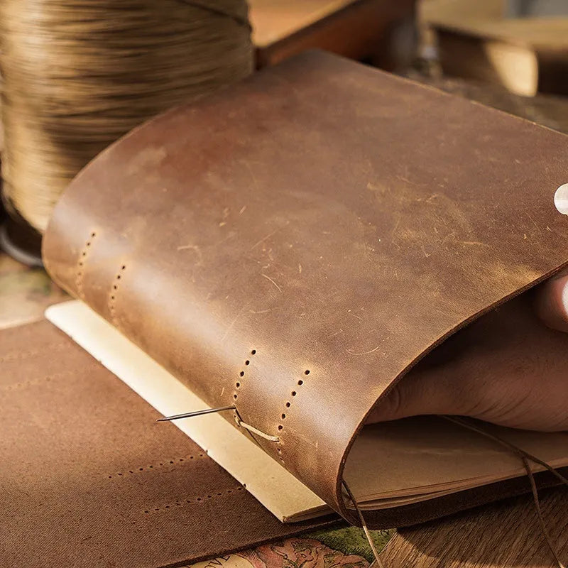 Brown crazy horse leather handmade notebook open on a wooden surface showing 200 pages of Daolin paper