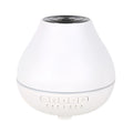 White round Bluetooth humidifier and aroma diffuser with night light function on wooden surface
