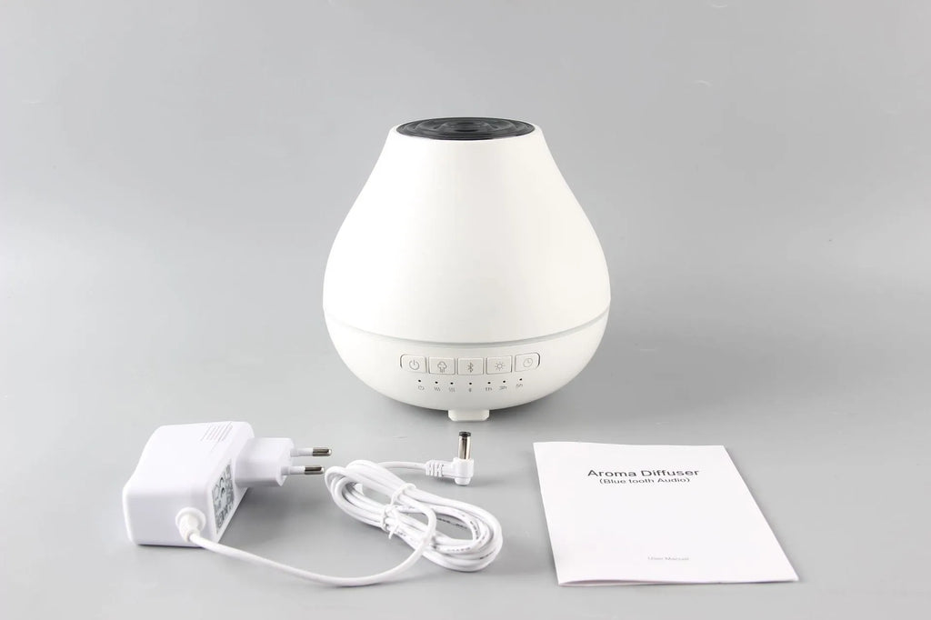 White round Bluetooth humidifier and aroma diffuser with night light function on wooden surface