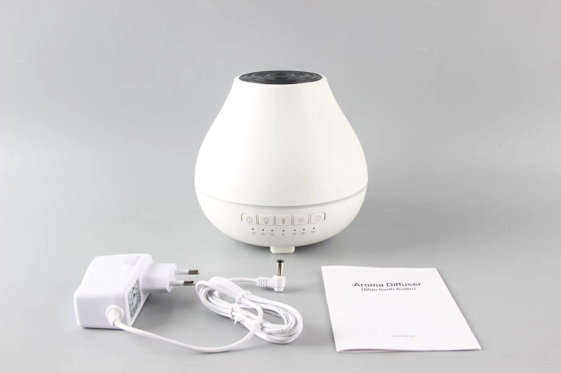 White round Bluetooth humidifier and aroma diffuser with night light function on wooden surface