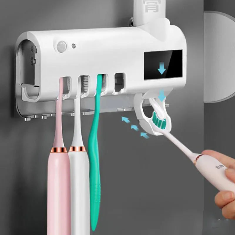 Black and white wall-mounted UV toothbrush steriliser with automatic toothpaste squeezer, showing solar panel and sensor.