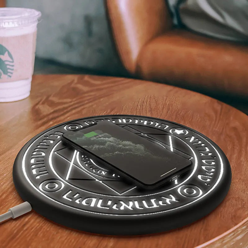 Square black wireless charging pad with glowing geometric pattern for Qi-compatible phones