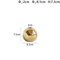 Handmade spherical ceramic vase with electroplated gold finish on a table