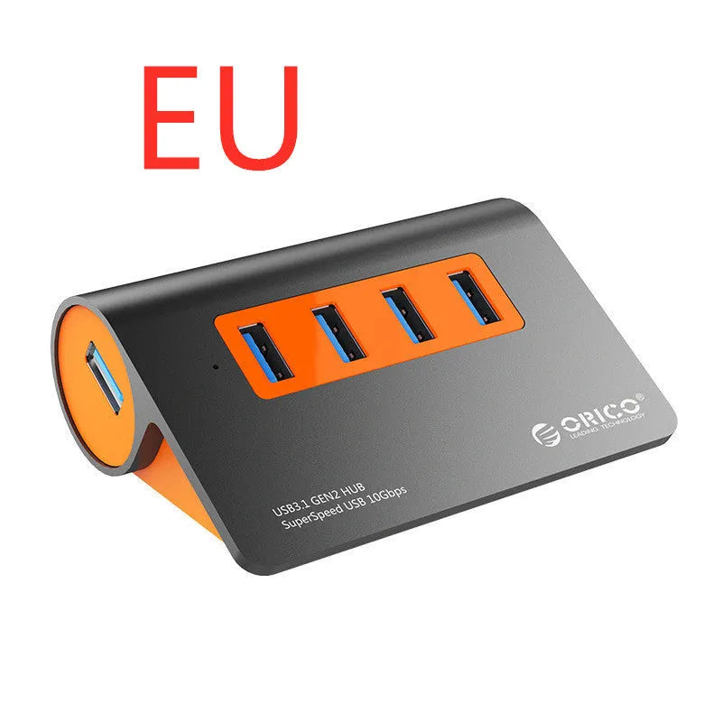 Dark grey aluminium USB hub with orange accents showing four USB 3.1 ports and separate data cable