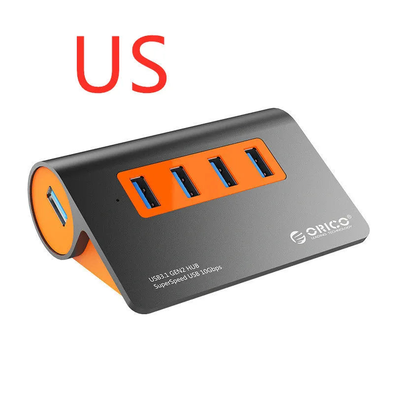 Dark grey aluminium USB hub with orange accents showing four USB 3.1 ports and separate data cable