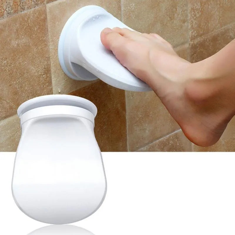 White plastic bathroom shower foot rest with suction cups on smooth tile
