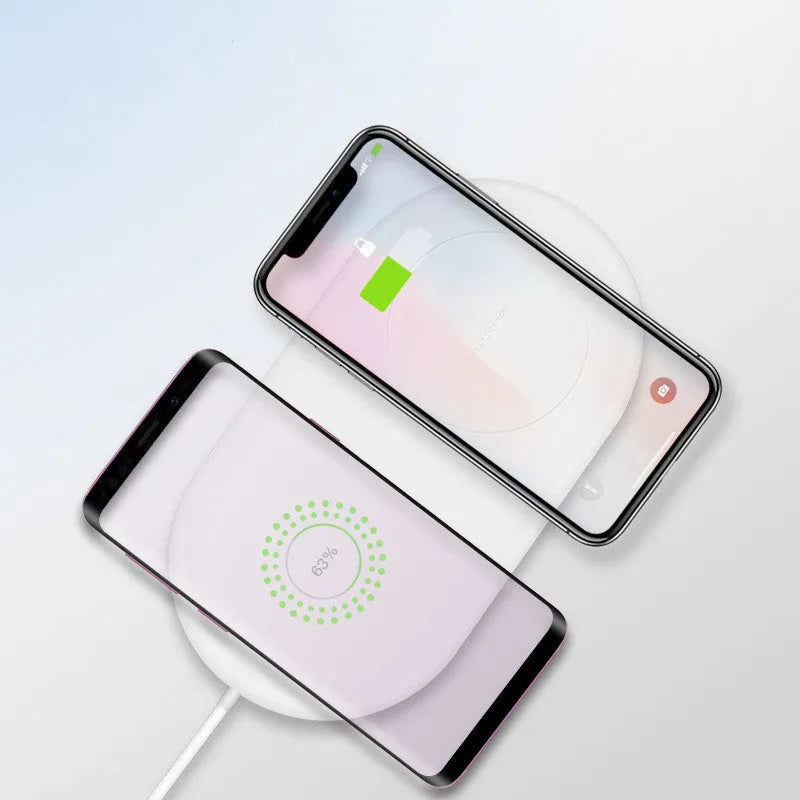 White dual wireless charger for two mobile phones on a table.