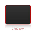 Large black and red seaming mouse pad on a desk with a computer mouse on it
