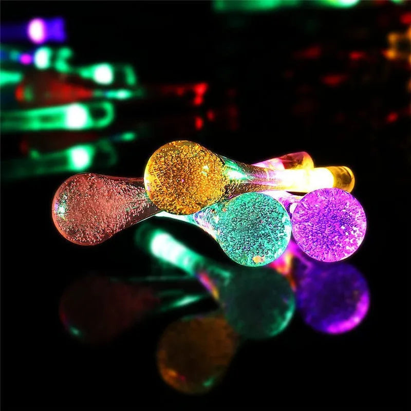 Solar-powered LED Water Drops string lights installed outdoors with 30 bulbs on a 6.5 metre waterproof cable