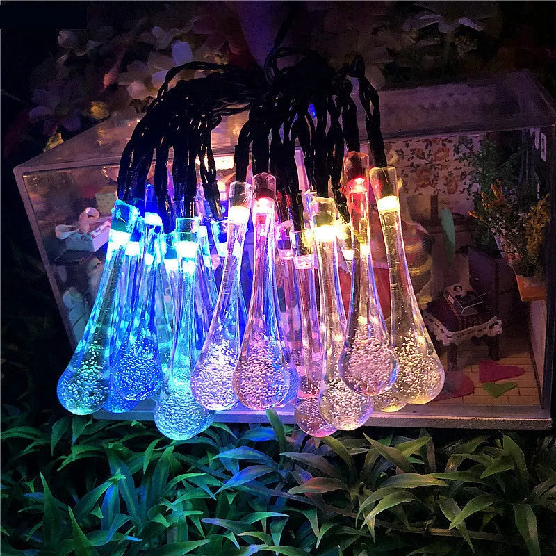Solar-powered LED Water Drops string lights installed outdoors with 30 bulbs on a 6.5 metre waterproof cable