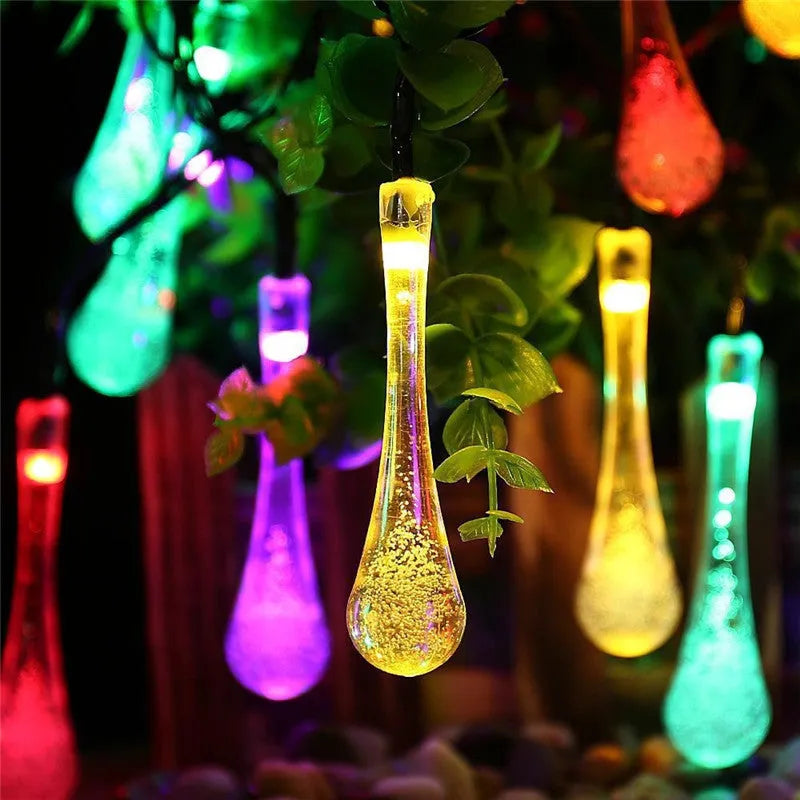 Solar-powered LED Water Drops string lights installed outdoors with 30 bulbs on a 6.5 metre waterproof cable