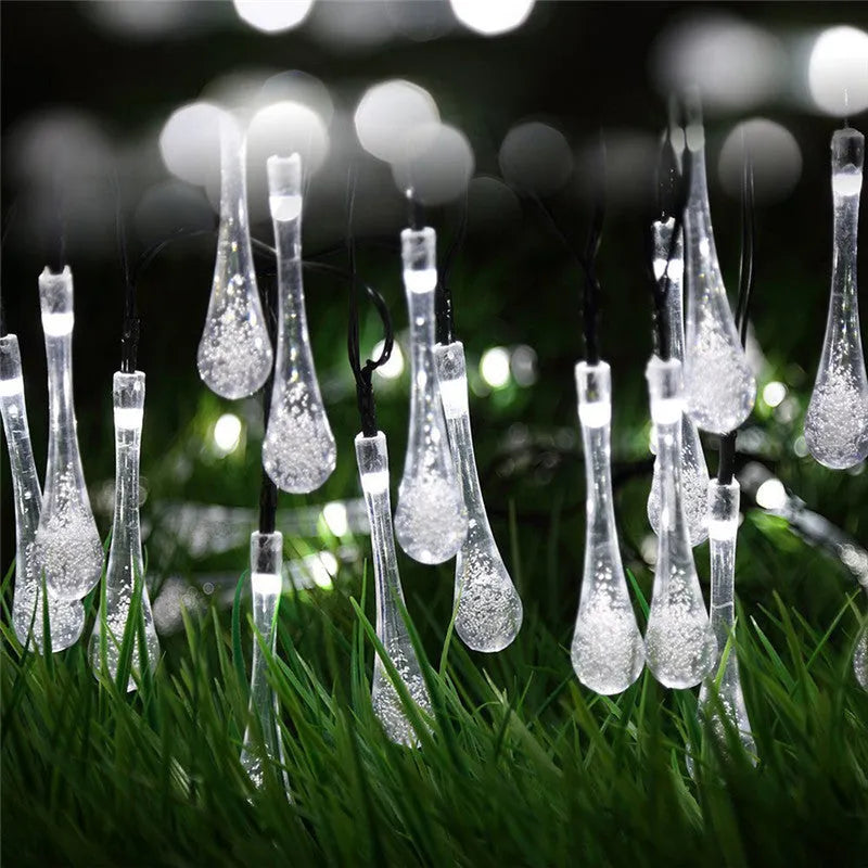 Solar-powered LED Water Drops string lights installed outdoors with 30 bulbs on a 6.5 metre waterproof cable