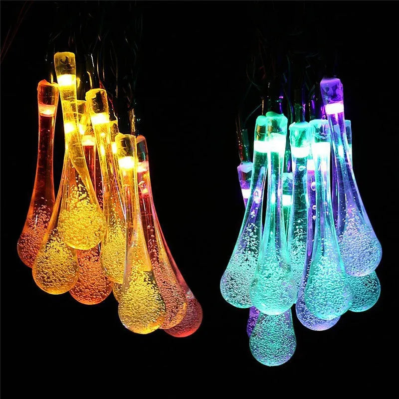 Solar-powered LED Water Drops string lights installed outdoors with 30 bulbs on a 6.5 metre waterproof cable