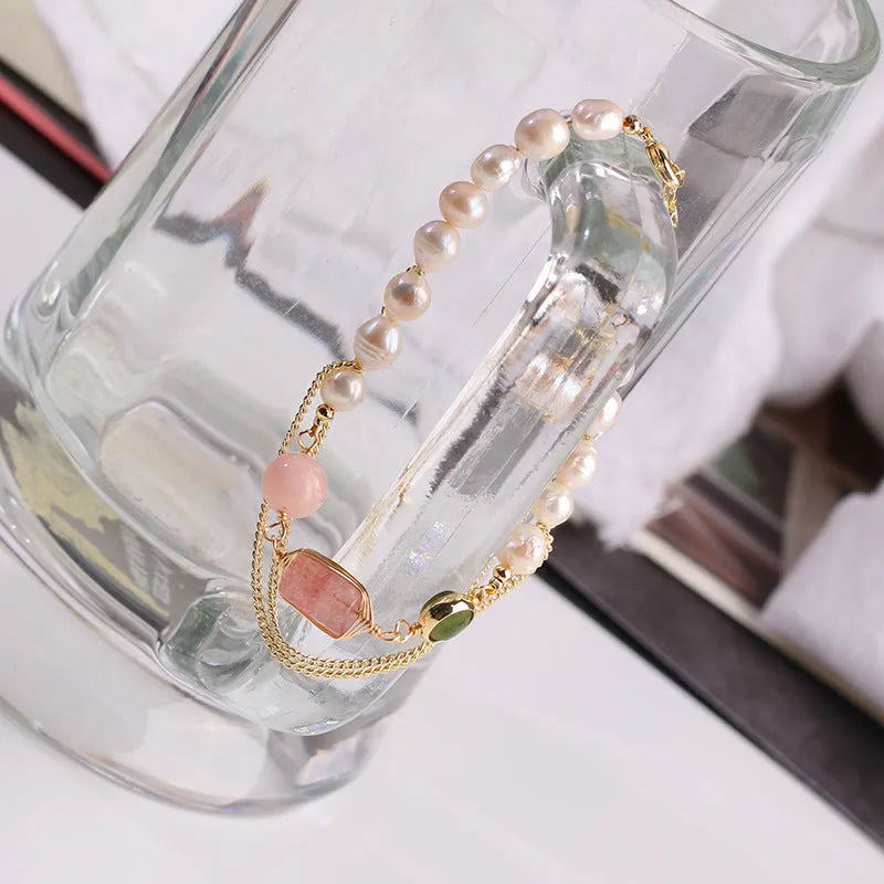 Geometric pink bracelet with natural freshwater pearls and strawberry crystals on a white background.