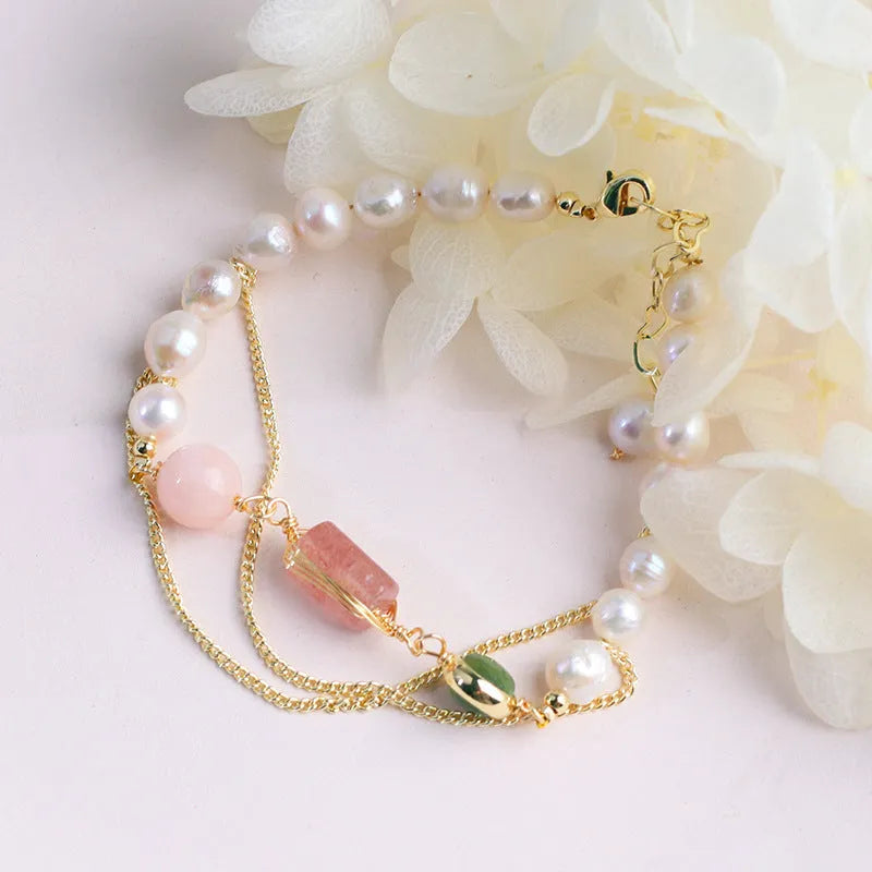 Geometric pink bracelet with natural freshwater pearls and strawberry crystals on a white background.