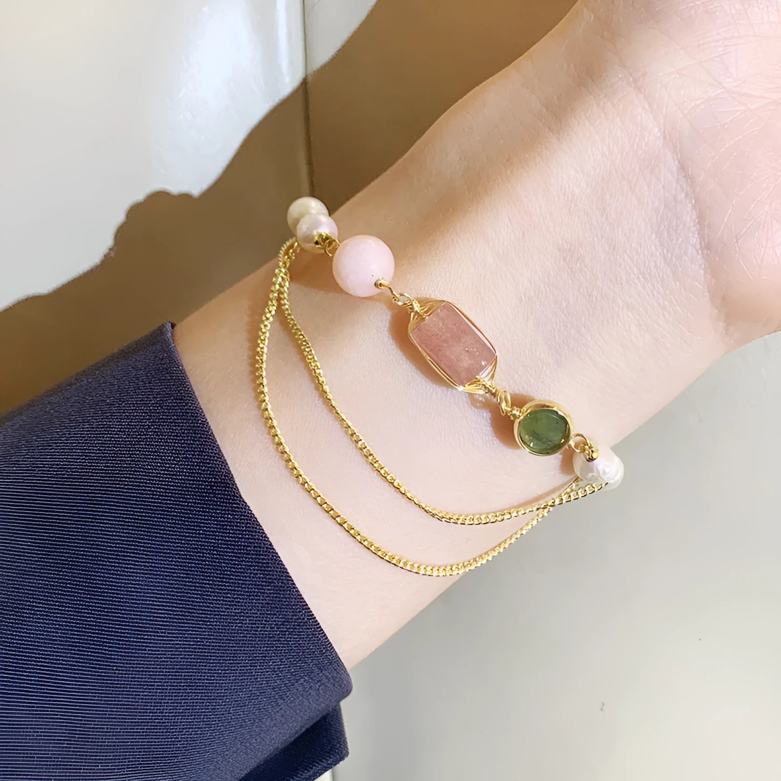 Geometric pink bracelet with natural freshwater pearls and strawberry crystals on a white background.