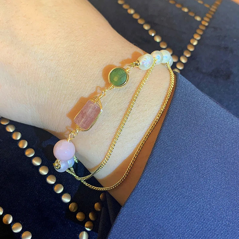 Geometric pink bracelet with natural freshwater pearls and strawberry crystals on a white background.