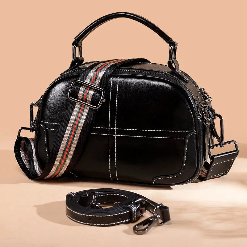 Round leather handbag with soft handle and zipper closure in wine red colour