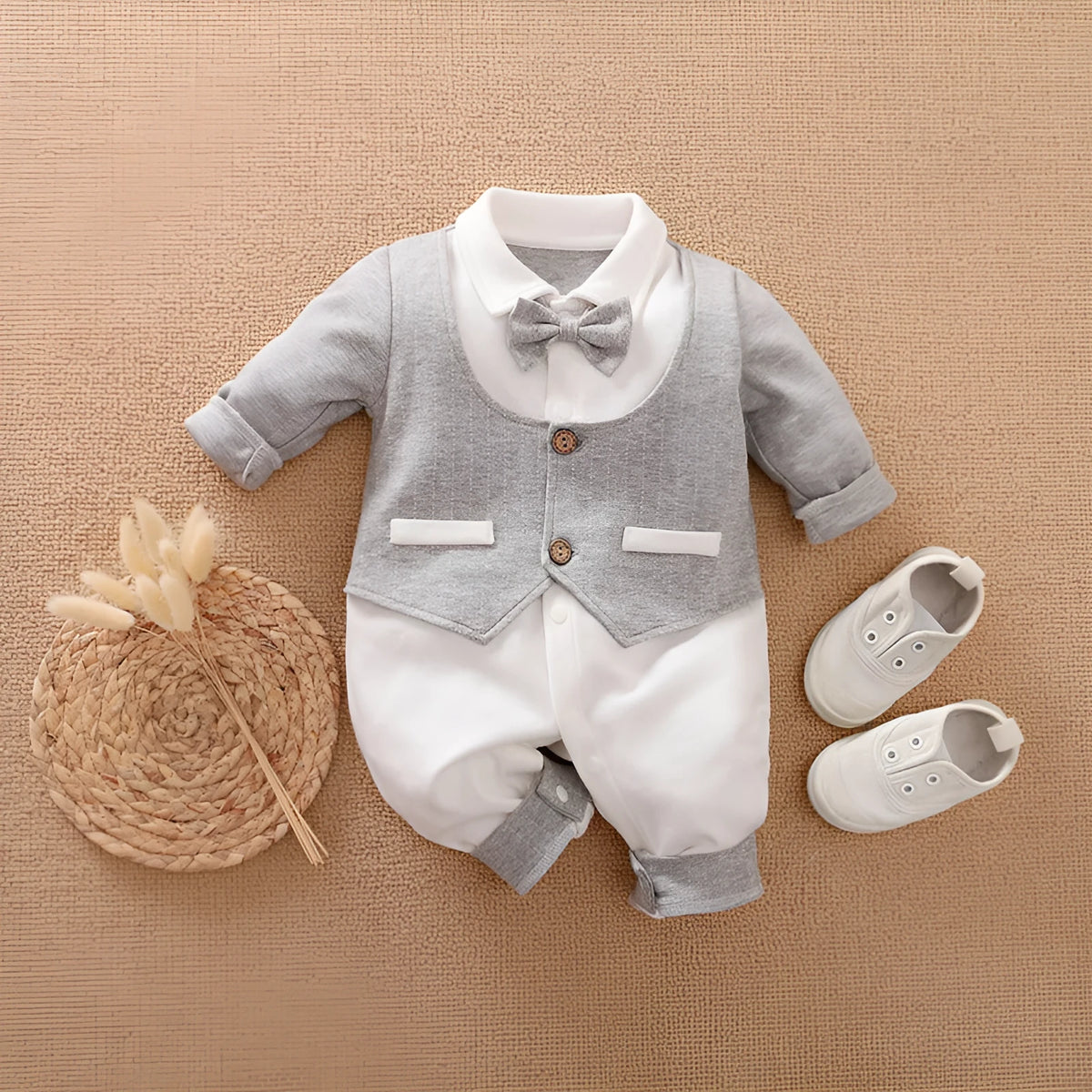 Baby boy wearing a long-sleeved gentleman-style cotton romper in a neutral colour.
