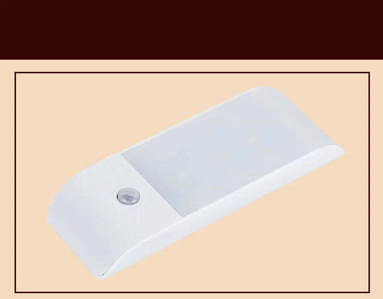 White rechargeable human body sensor LED night light with PVC shade on a cabinet.