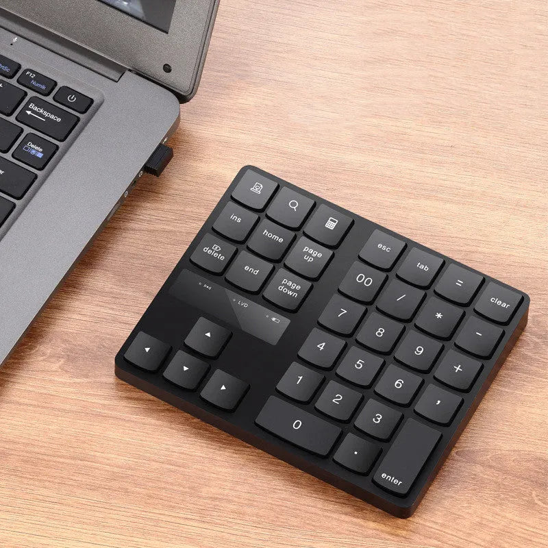 Black wireless numeric keyboard with 35 keys on a desk
